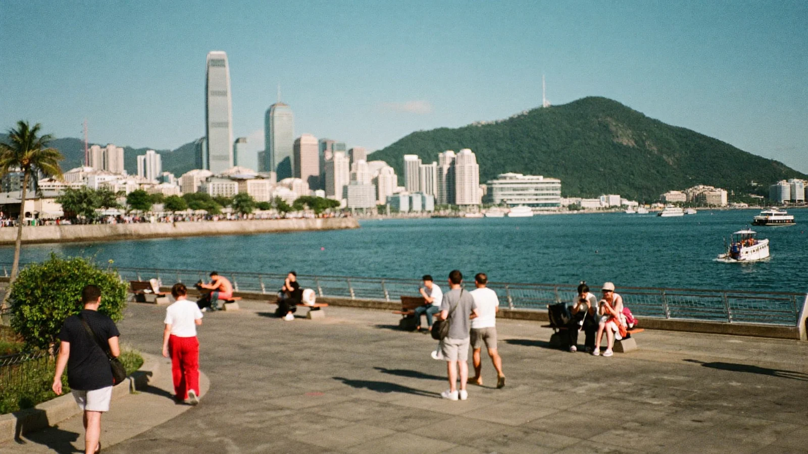 夏日午後，市民喺香港海濱長廊漫步，對岸就係港島天際線 —— 此為本週好去處指南嘅示意圖片