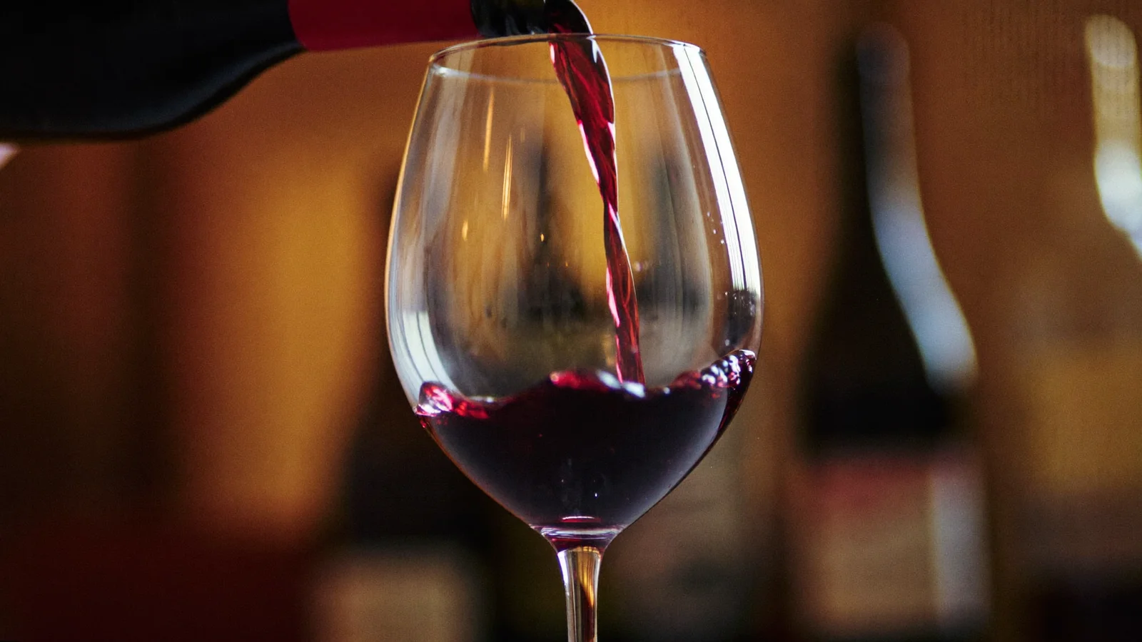 Several glasses of red and white wine arranged on a wooden tasting table with a tasting notes sheet, local Hong Kong Chinese hands pouring a pour, illustrative image for this wine tasting guide, not a photo of any specific venue