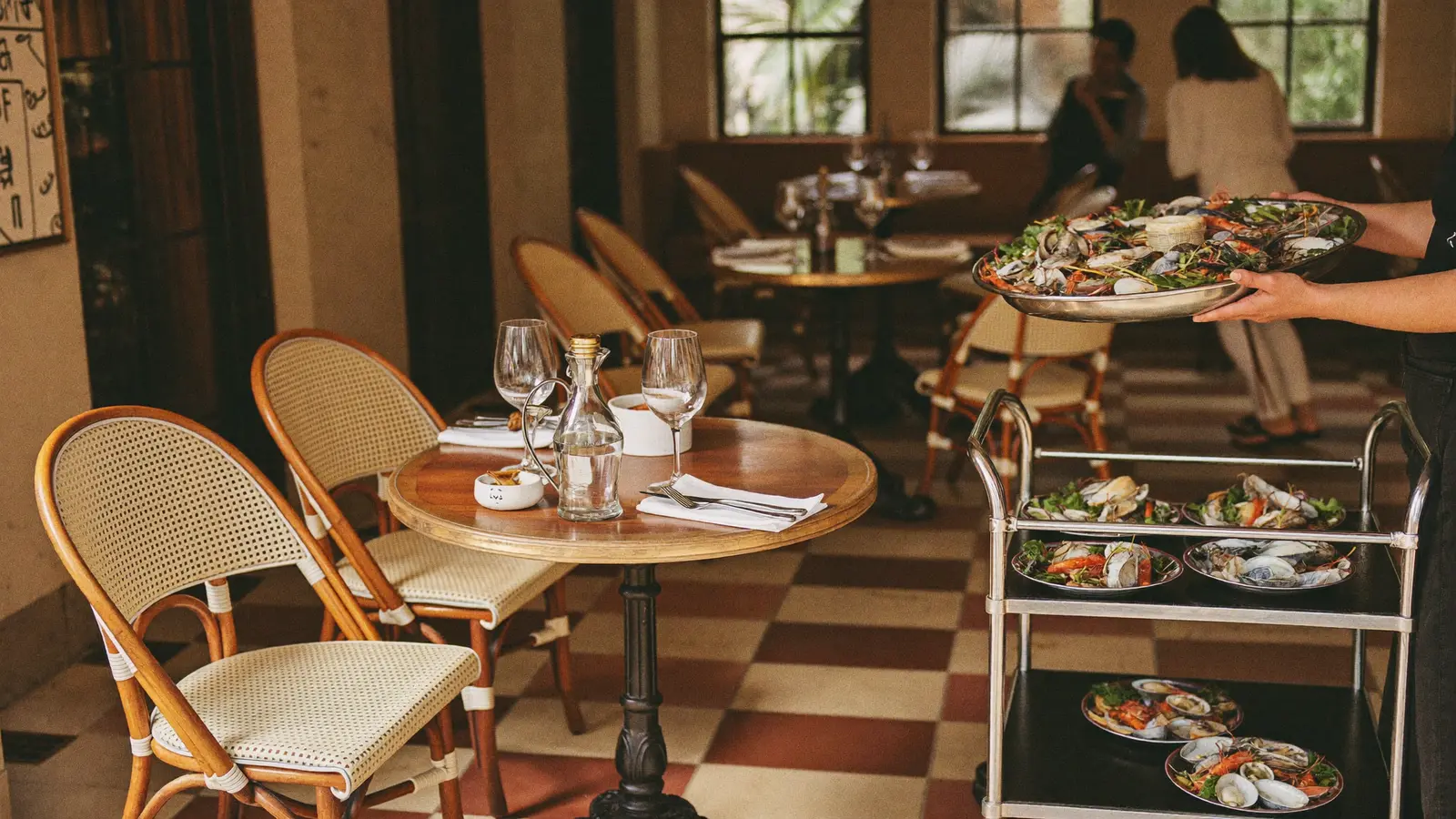 A sun-drenched restaurant terrace with warm Tuscan-inspired decor, table-side seafood service and soft natural light, illustrating the reopened Cafe Landmark in Central - an illustrative image, not a photo of the actual restaurant