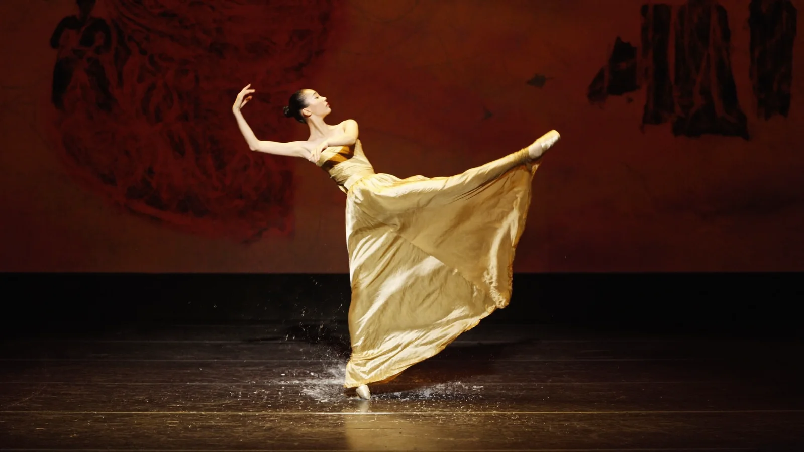 A ballet dancer mid-leap on a dramatically lit stage with flowing silk fabric evoking Dunhuang mural art - illustrative hero for this Hong Kong Ballet guide, not a photo from the actual production