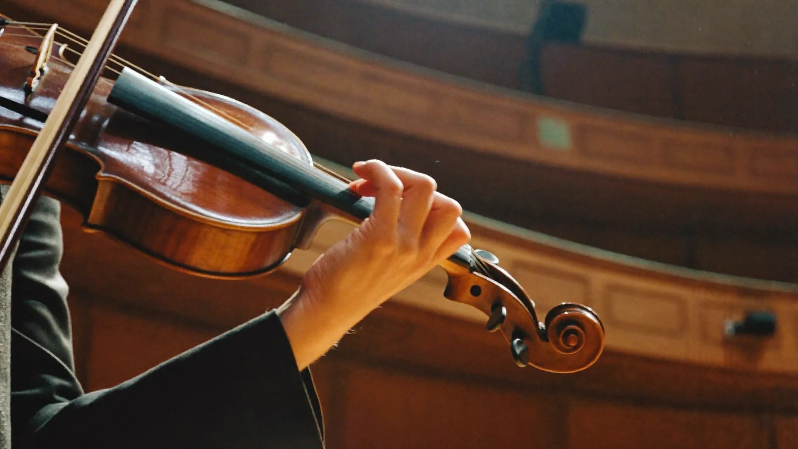 Close-up of a violinist's hands playing on stage, illustrative image for this Great Music 2026 Hong Kong autumn concerts guide, not a photo of the actual performers or venue