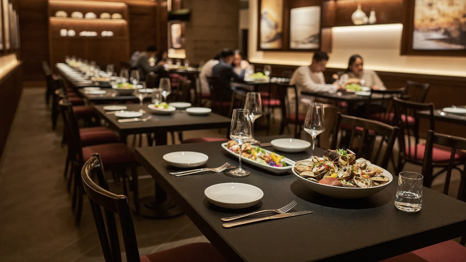 An elegant Chinese restaurant dining room with dark wood tables and a plated seafood dish, local Hong Kong Chinese diners in soft focus, illustrative image for this Hokkien House H Queen's restaurant guide, not a photo of the actual restaurant or dishes