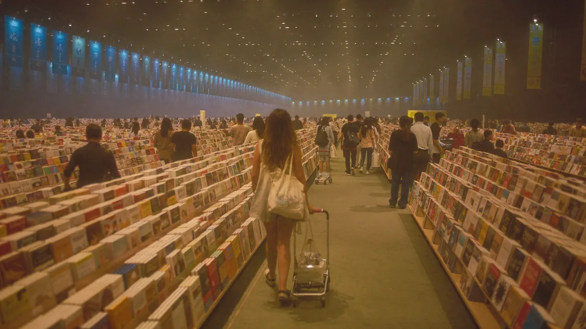 Crowds browsing tall stacks of books at the Hong Kong Book Fair in Wan Chai