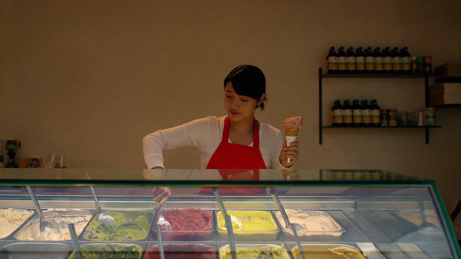 An ice cream shop worker scooping colourful gelato at a display counter, representing this week's new Hong Kong openings