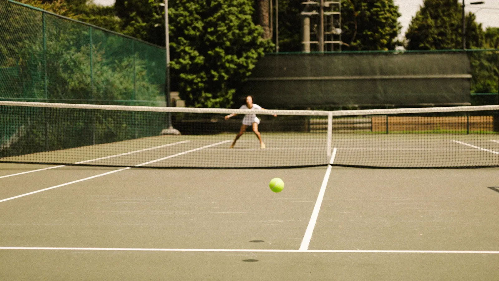 An outdoor hard tennis court with fresh white line markings under bright daylight, illustrating the Prudential Hong Kong Tennis Open at Victoria Park - an illustrative image, not a photo from the actual tournament