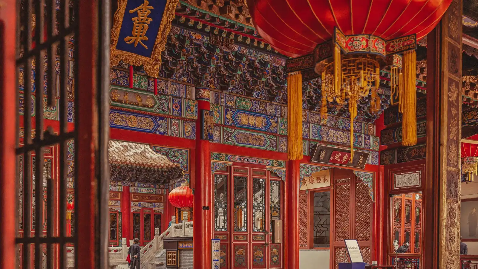 Ornate red and gold Qing dynasty palace architecture with traditional lanterns, illustrating the Hong Kong Palace Museum exhibition on imperial court life - an illustrative image, not a photo of the actual exhibition objects