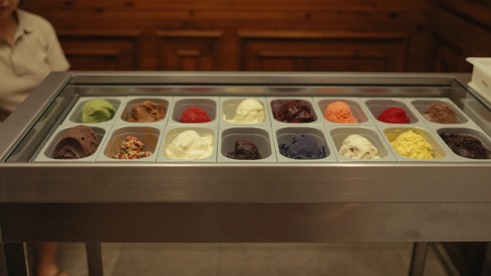 A small, retro-styled Hong Kong ice cream shop counter with a single-scoop display case, deep brown wooden walls and warm lighting, local Hong Kong Chinese customers softly blurred browsing antique stalls just outside, illustrative image for this Cat Street ice cream shop guide, not a photo of the actual venue